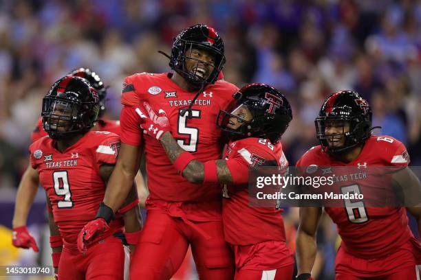 Myles Cole and Dadrion Taylor-Demerson of the Texas Tech Red Raiders celebrate a stop against the Mississippi Rebels during the first half at NRG...