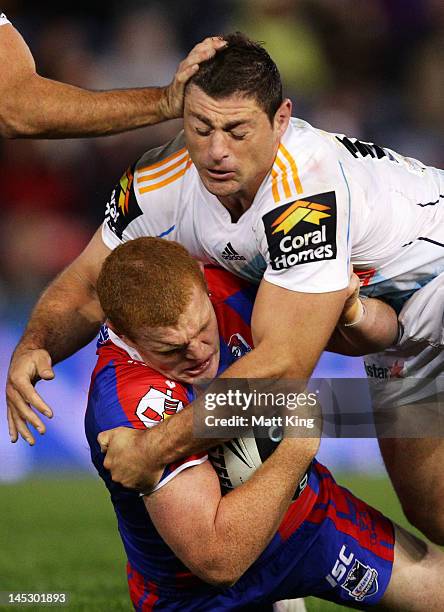 Alex McKinnon of the Knights is tackled by Mark Minichiello of the Titans during the round 12 NRL match between the Newcastle Knights and the Gold...