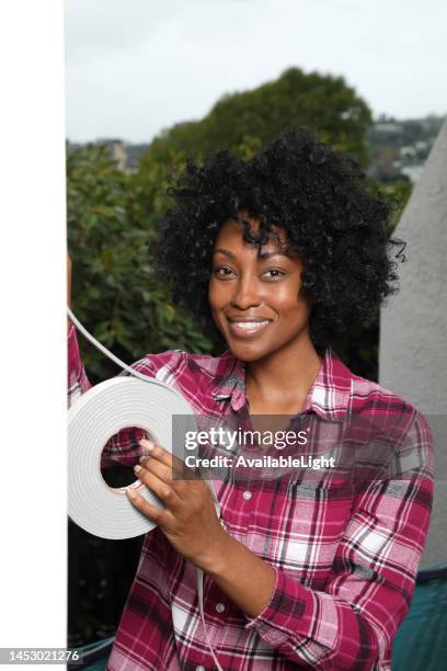 african american weather stripping woman smiles at camera vertical - weather stripping stock pictures, royalty-free photos & images