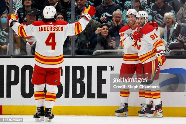 Nazem Kadri of the Calgary Flames celebrates his goal with Rasmus Andersson and Elias Lindholm during the second period at Climate Pledge Arena on...