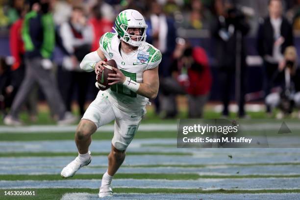 Bo Nix of the Oregon Ducks rolls out to pass during the second half of the San Diego Credit Union Holiday Bowl game against the North Carolina Tar...