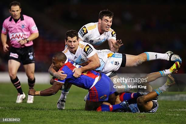 Akuila Uate of the Knights is tackled heavily by Greg Bird and Luke Douglas of the Titans during the round 12 NRL match between the Newcastle Knights...