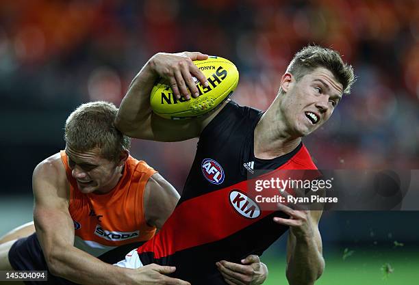 Jake Melksham of the Bombers is tackled by Adam Treloar of the Giants during the round nine AFL match between the Greater Western Sydney Giants and...