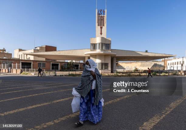 Woman crosses the street in front of the Fiat Tagliero Building in the city center on December 28, 2022 in Asmara, Eritrea. Completed in 1938, the...