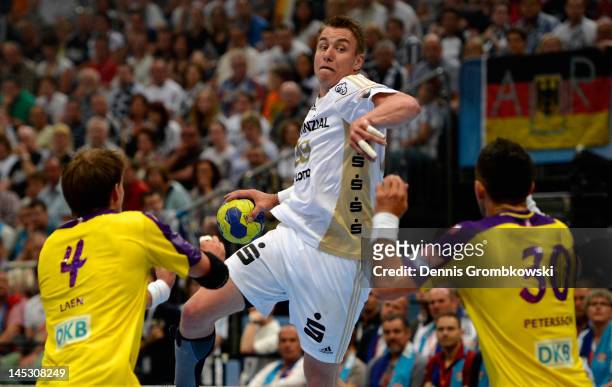 Fliip Jicha of Kiel throws the ball under the pressure of Torsten Laen and Alexander Petersson of Berlin during the EHF Final Four semi final match...