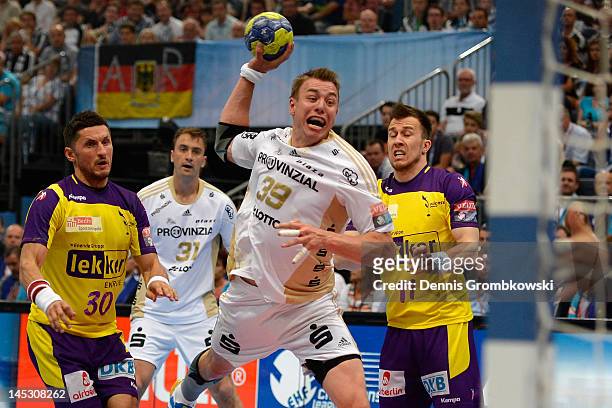 Fliip Jicha of Kiel throws the ball under the pressure of Markus Riechwien and Alexander Petersson of Berlin during the EHF Final Four semi final...