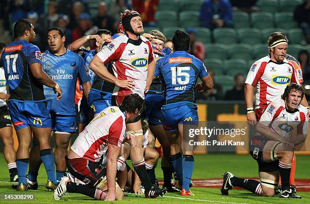 Franco Van Der Merwe of the Lions walks past the Force players as they celebrate a try during the round 14 Super Rugby match between the Western...