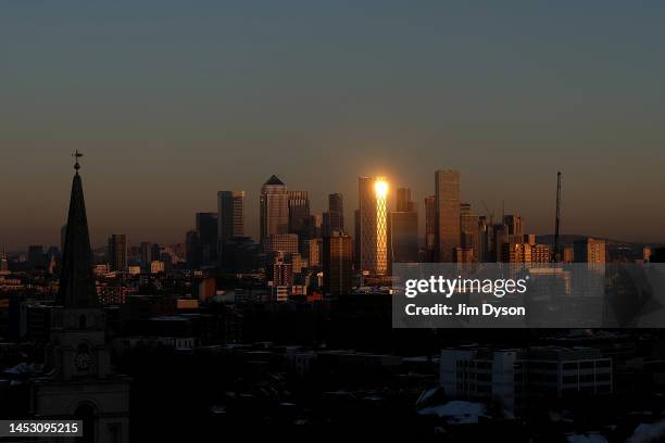 The setting sun reflects off the Newfoundland tower in the Canary Wharf financial district on December 14, 2022 in London, England. Below-zero...