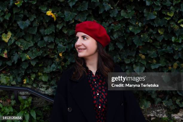 portrait of a young woman in a red beret. girl outdoors in the park. - girl in red beret stock pictures, royalty-free photos & images