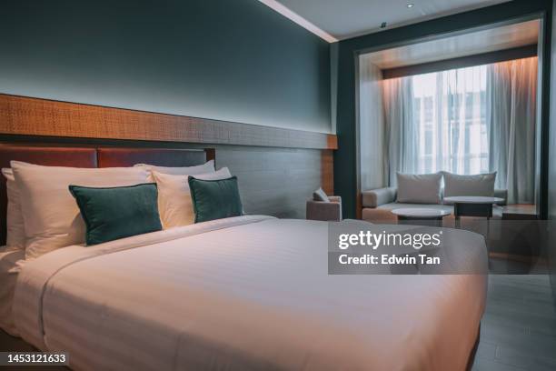 modern hotel room with double bed, night tables and day sofa bed - double bed stock pictures, royalty-free photos & images