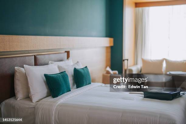 modern hotel room with double bed, night tables and day sofa bed - tidy room stock pictures, royalty-free photos & images