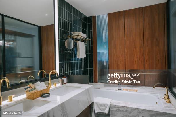modernes interieur hotelbadezimmer mit doppelwaschbecken mit marmorwaschtisch und badewanne - bathroom vanity stock-fotos und bilder