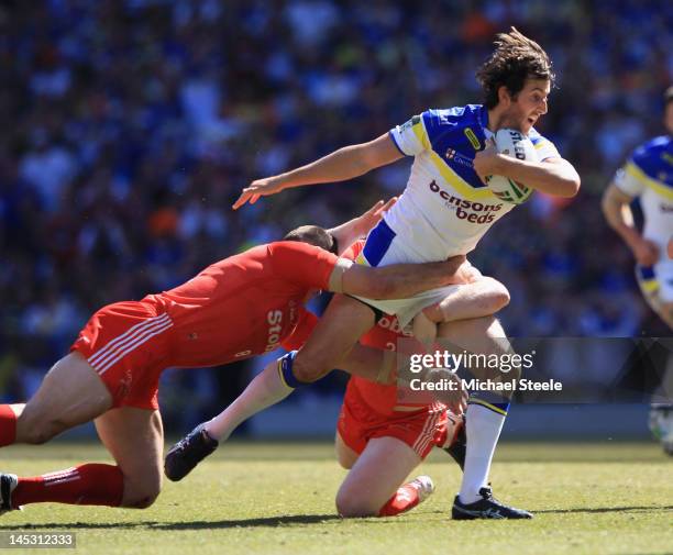 Stefan Ratchford of Warrington Wolves is held up by Ben Cross and Paddy Flynn of Widnes Vikings during the Stobart Super League 'Magic Weekend' match...