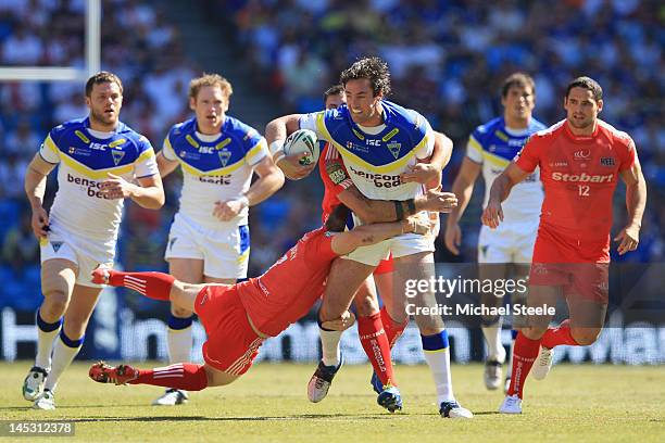 Trent Waterhouse of Warrington Wolves is held up by Rhys Hanbury of Widnes Vikings during the Stobart Super League 'Magic Weekend' match between...