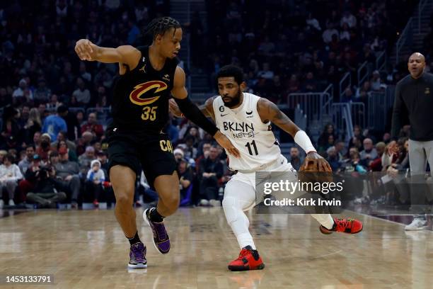 Kyrie Irving of the Brooklyn Nets dribbles the ball up the court against the defense of Isaac Okoro of the Cleveland Cavaliers during the game at...