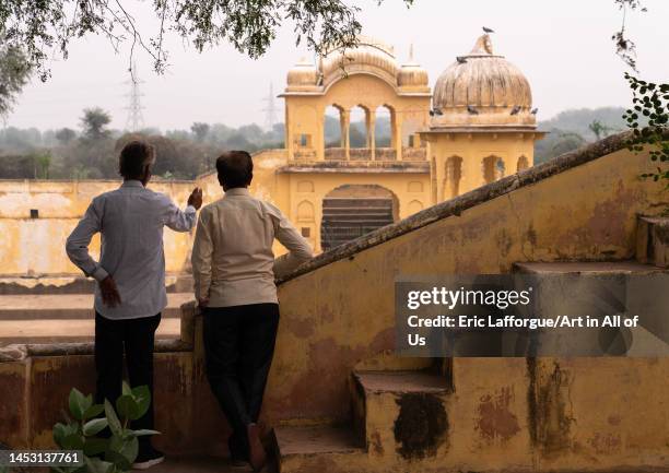 Indian men in front of a stepwell, Rajasthan, Ramgarh Shekhawati, India on November 8, 2022 in Ramgarh Shekhawati, India.