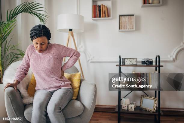 woman has back problems - backache stock pictures, royalty-free photos & images