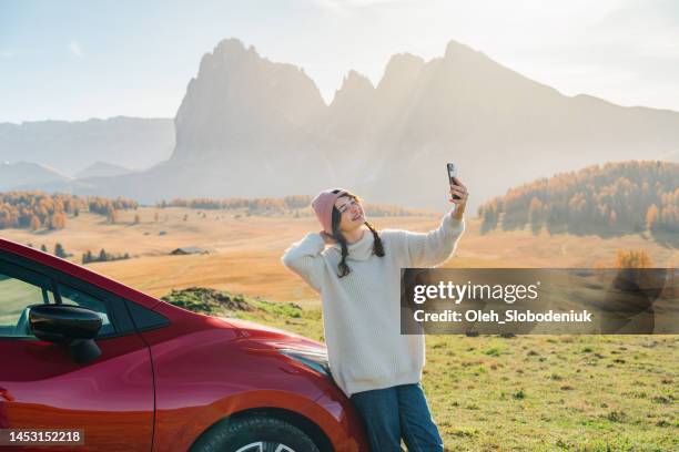 woman taking selfie near the car in seiser alm - seiser alm stock pictures, royalty-free photos & images