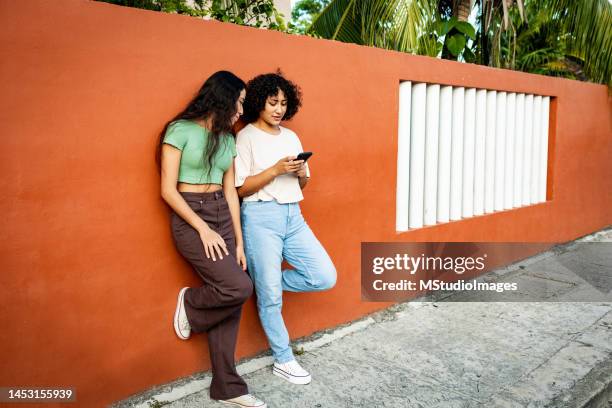 two women standing on the street and using mobile phone - tourist talking on the phone stock pictures, royalty-free photos & images