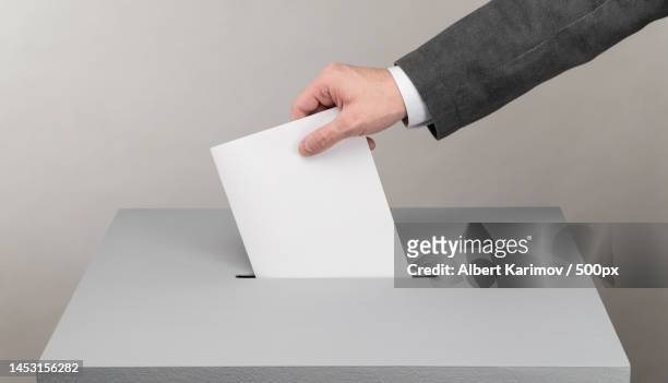cropped hand of businessman holding blank visiting card against white background,uzbekistan - ballot box stock-fotos und bilder
