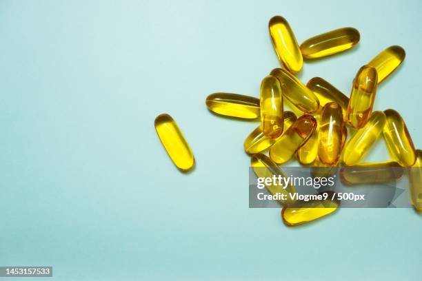 directly above shot of capsules over blue background - huile de foie de morue photos et images de collection
