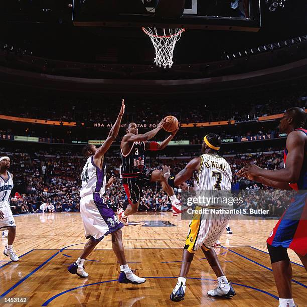 Steve Francis of the Houston Rockets drives to the basket against Ray Allen of the Milwaukee Bucks and Jermaine O''Neal of the Indiana Pacers during...