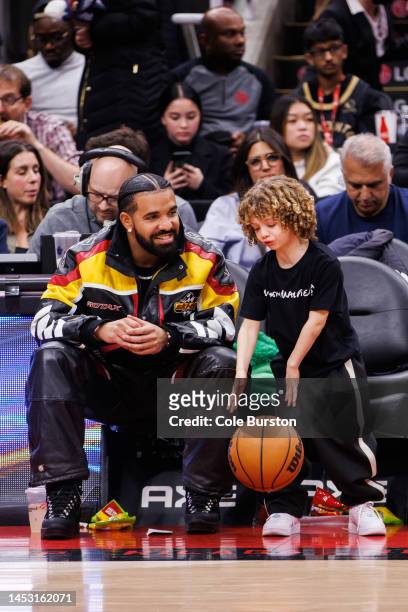 Rapper Drake plays with his son Adonis during the second half of the NBA game between the Toronto Raptors and the LA Clippers at Scotiabank Arena on...