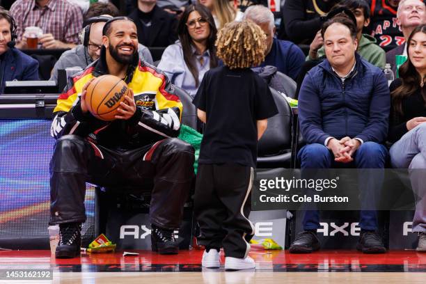 Rapper Drake plays with his son Adonis during the second half of the NBA game between the Toronto Raptors and the LA Clippers at Scotiabank Arena on...