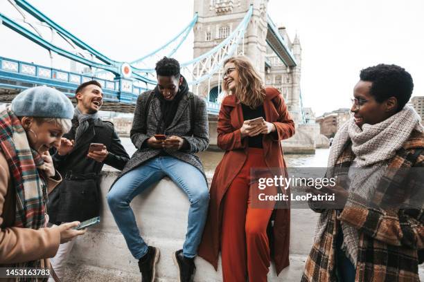 group of friends on vacation texting on mobile - london tourist stock pictures, royalty-free photos & images