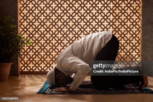 portrait of a muslim man praying at home - namaz stock-fotos und bilder