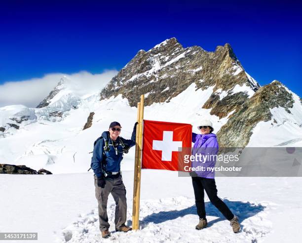 pareja mayor en la cima de jungfraujoch, suiza - swiss flag fotografías e imágenes de stock