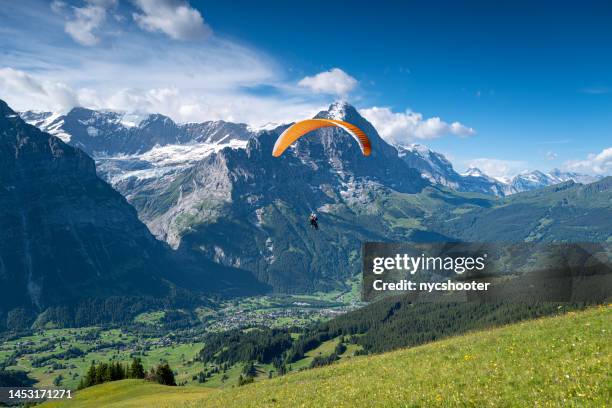 paragliding over grindelwald, switzerland - grindelwald stock pictures, royalty-free photos & images