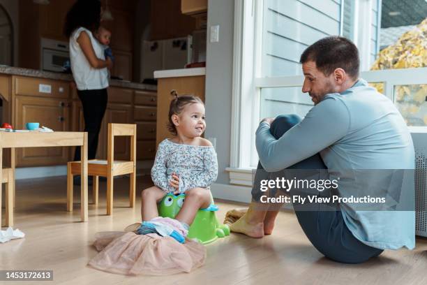 dad helping toddler daughter with potty training - potty training stock pictures, royalty-free photos & images