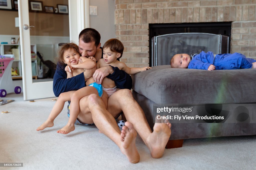 Dad playing with his children at home