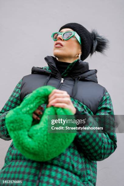 German presenter Verena Kerth, wearing a green and black checked jacket with hood by Stella Sabatoni, black pants by Wolford, a black knitted cap...