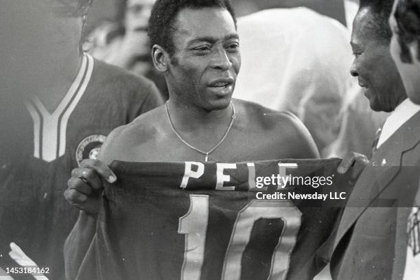 East Rutherford, N.J.: Soccer star Pele hands his No.10 Cosmos shirt to his father at Pele's farewell game at Giants Stadium in New Jersey on October...