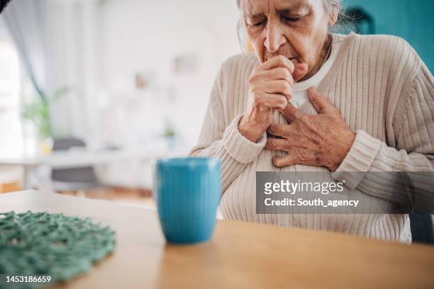 old woman coughing - só uma mulher idosa imagens e fotografias de stock