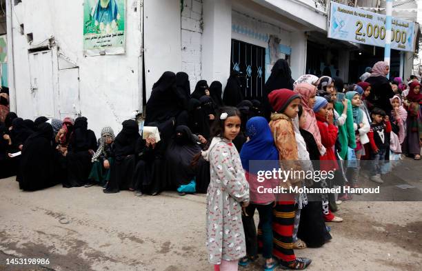 Yemeni girls from families affected by war line up to receive free meals provided by a charitable kitchen on December 29, 2022 in Sana'a, Yemen....