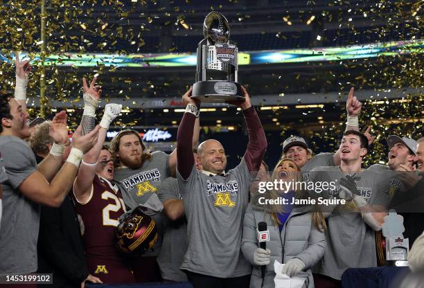 Head coach P. J. Fleck of the Minnesota Golden Gophers lifts the championship trophy after Minnesota defeated the Syracuse Orange to win the Bad Boy...