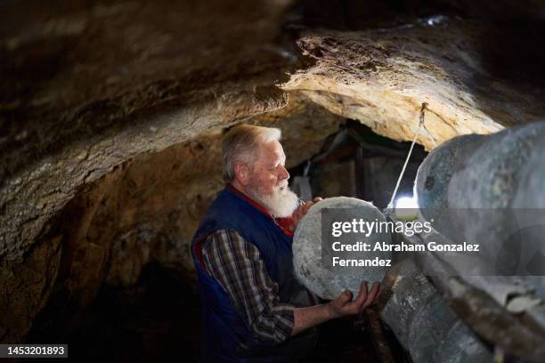 farmer ordering cheeses inside a cave for curing - fermenting stock pictures, royalty-free photos & images