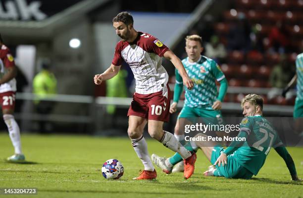 Danny Hylton of Northampton Town moves away with the ball from Angus MacDonald of Swindon Town during the Sky Bet League Two between Northampton Town...