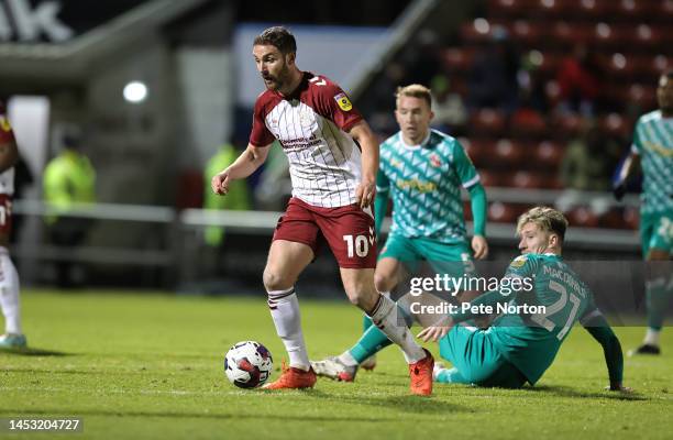 Danny Hylton of Northampton Town moves away with the ball from Angus MacDonald of Swindon Town during the Sky Bet League Two between Northampton Town...