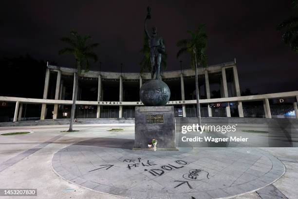 Flowers are laid for late football legend Pele at Bellini statue as a graffiti on the floor reads in Portuguese 'King Pele, Idol' outside Maracana...