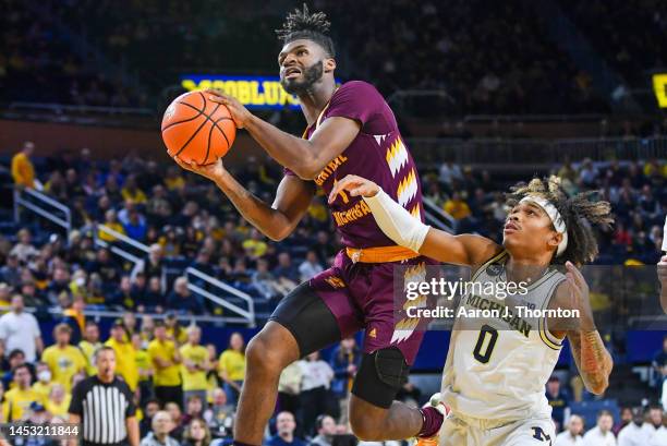 Reggie Bass of the Central Michigan Chippewas attempts a shot after getting past Dug McDaniel of the Michigan Wolverines during the first half of a...