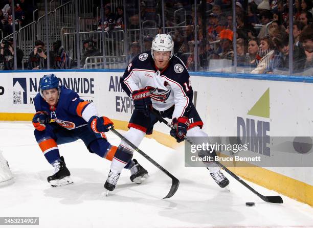 Gustav Nyquist of the Columbus Blue Jackets moves the puck ahead of Ryan Pulock of the New York Islanders during the first period at UBS Arena on...