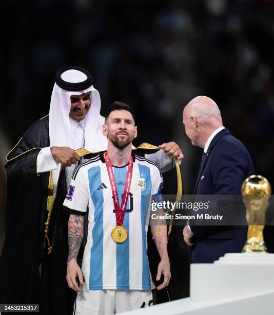 Lionel Messi of Argentina is presented a traditional robe by the Emir of Qatar, Sheik Tamim bin Hamad Al Thani, during the trophy presentation...