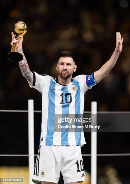 Lionel Messi of Argentina raises his arms as he collects the Golden Ball award following the FIFA World Cup Qatar 2022 Final match between Argentina...