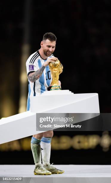 Lionel Messi of Argentina touches the FIFA World Cup trophy as he collects the Golden Ball award following the FIFA World Cup Qatar 2022 Final match...
