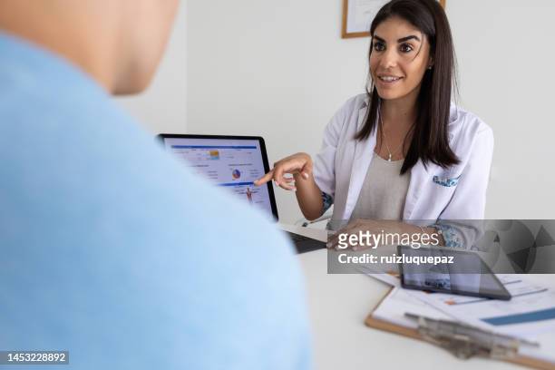 female nutricionist doctor and deportologist in her desk's office during a medical consultation with teenager boy patient - body mass index chart stock pictures, royalty-free photos & images