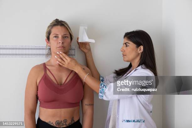 female nutritionist and deportologist mesuring height on a female patient with anthropometric instruments during medical consultation - body mass index chart stock pictures, royalty-free photos & images